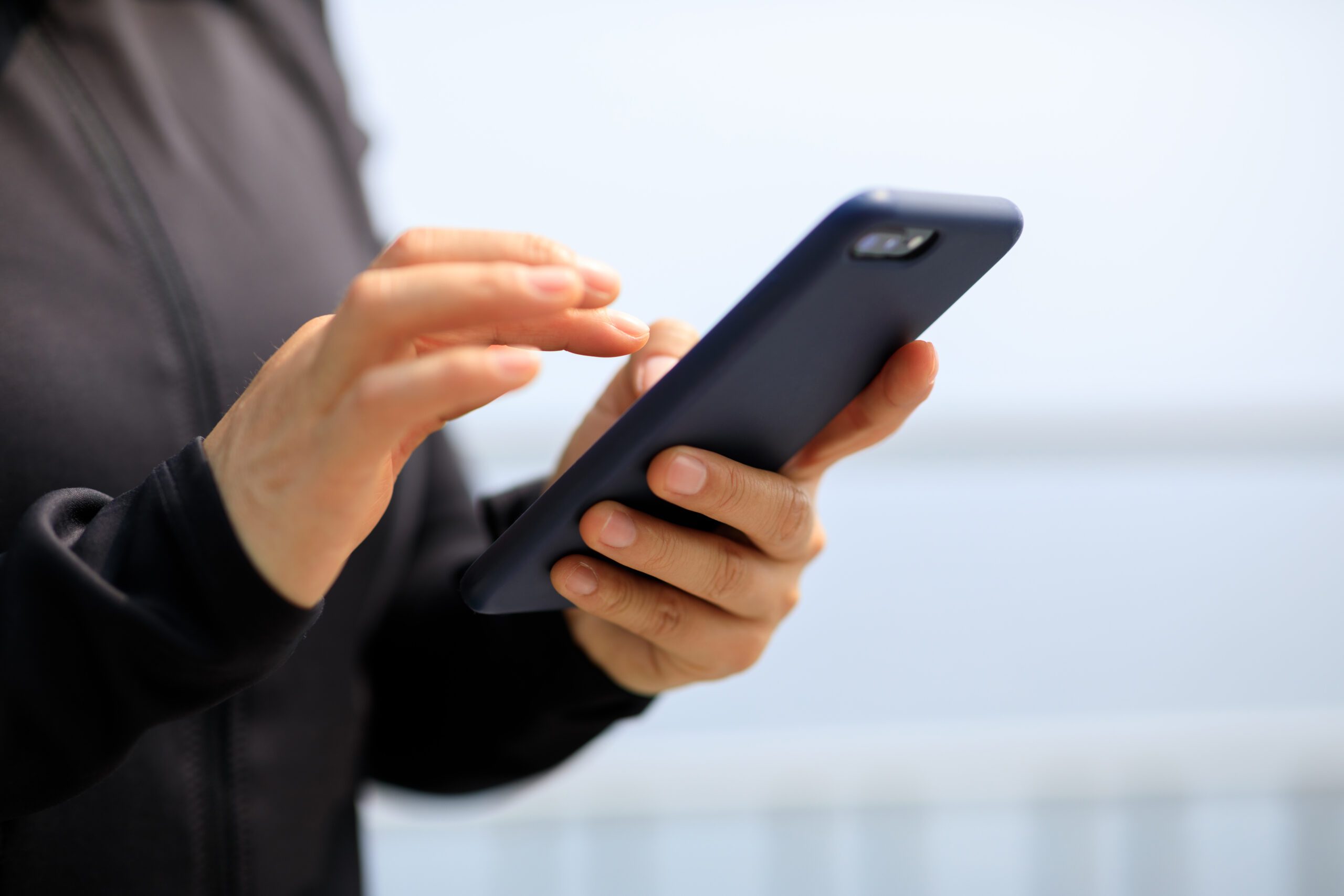 Asian woman using smartphone outdoors